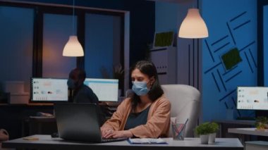 İş yerinde çalışan ve yüz maskesi takan çok çalışan bir girişimci olan Covid19 'a karşı.