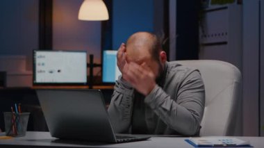 Finansal istatistiklerde çalışırken çok çalışan işadamı yüzünü ovalıyor