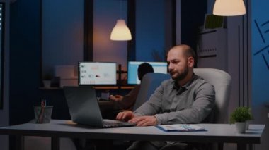 Mutlu başarılı iş adamı dizüstü bilgisayara bakarken gülümsüyor