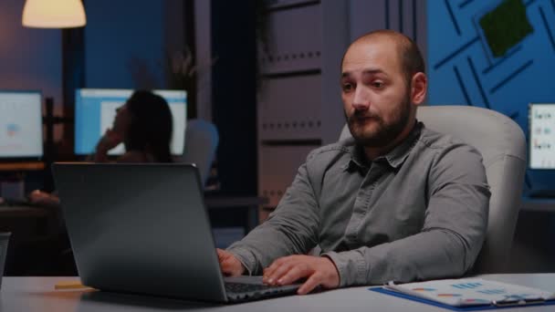 Feliz hombre de negocios alegre que trabaja en la oficina de la empresa startup tarde en la noche — Vídeos de Stock