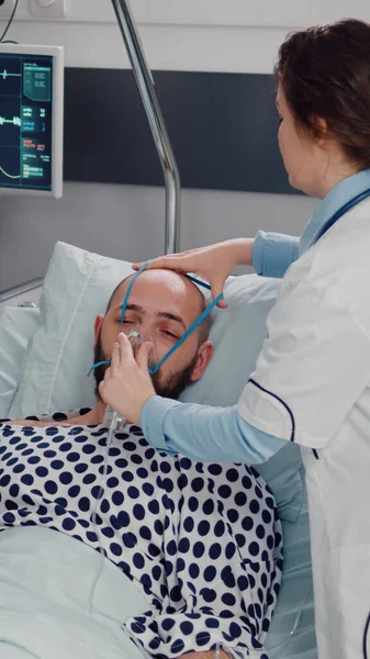 Equipe médica monitorando batimentos cardíacos de homem doente durante a consulta respiratória — Fotografia de Stock