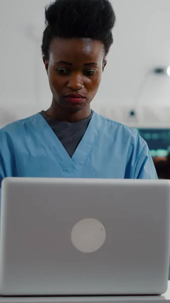 Assistente afro-americano che digita il sintomo di malattia sul computer — Foto Stock