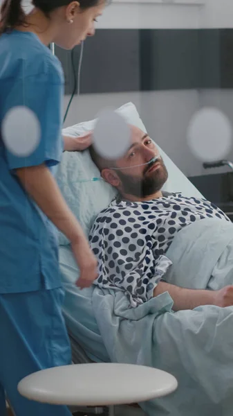 Άρρωστος που αναπαύεται στο κρεβάτι φορώντας ρινικό σωλήνα oygen περιμένοντας ιατρό για την εξέταση της νόσου — Φωτογραφία Αρχείου