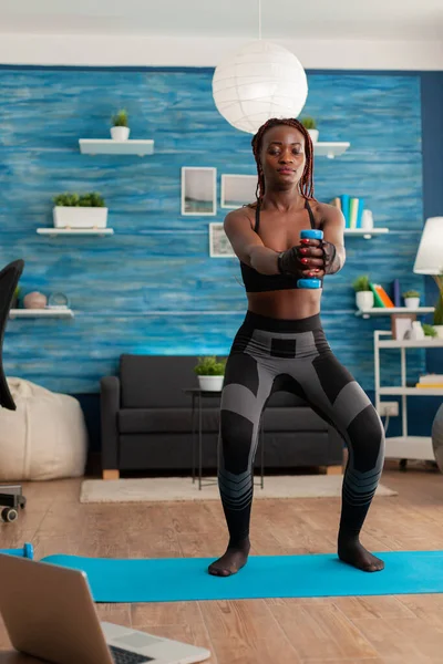 Atleta africano che fa squat con manubri vestiti in abbigliamento sportivo — Foto Stock