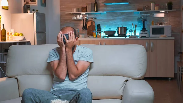 Homem concentrado sentado na frente da televisão enquanto assiste séries de shows divertidos — Fotografia de Stock