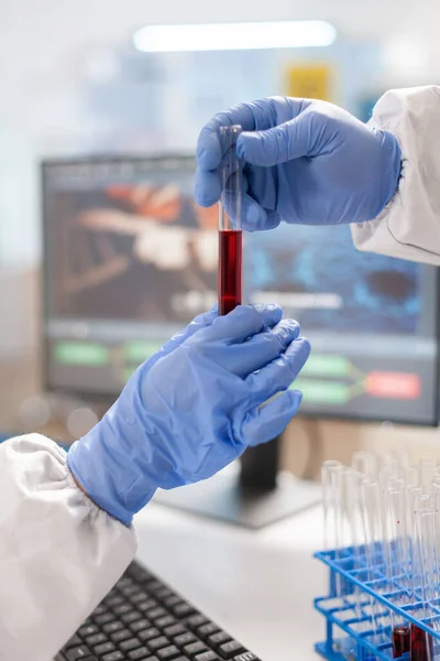 Крупный план ученых, одетых в костюм с трубкой для анализа крови — стоковое фото