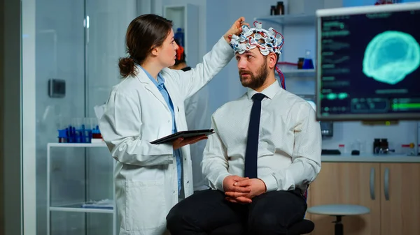 Man sitting on neurological chair with brainwave scanning headset — Stock Photo, Image