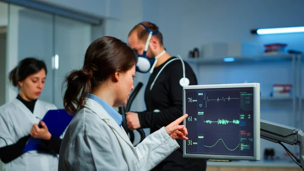 Muskelidrottare med mask som körs på crosstrainer i medicinskt laboratorium — Stockfoto