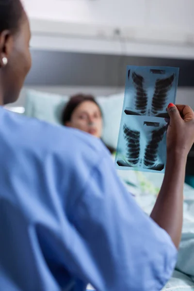 Gros plan d'une infirmière afro-américaine analysant la récupération des soins de santé par radiographie pulmonaire — Photo