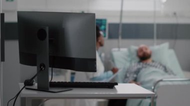 Siyah tenli pratisyen doktor hastalık tedavisini açıklıyor.