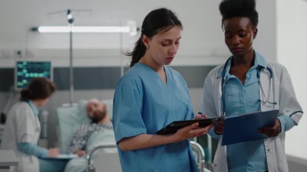 Медицинская сестра показывает медицинские знания с помощью планшетного компьютера для специалиста черный врач женщина — стоковое видео