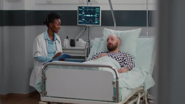 Uomo malato seduto a letto con tubo di ossigeno che spiega il sintomo della malattia — Video Stock