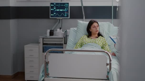 Kaukasische Hündin mit nasalem Sauerstoffschlauch sitzt auf Krankenhausstation im Bett — Stockvideo