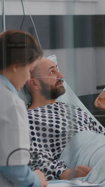 Patiënt in gesprek met artsen terwijl ze in bed liggen tijdens het herstel van de ziekte — Stockfoto