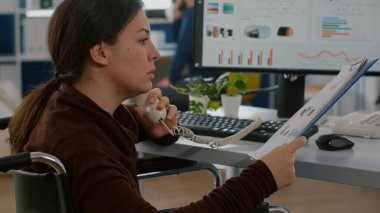 Felçli müşteri destek uzmanı müşteriyle telefonda konuşuyor.