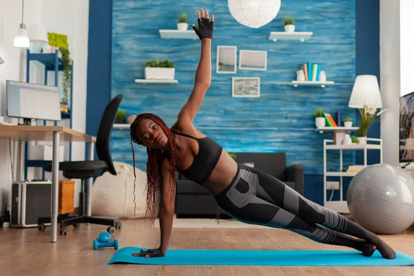 In forma atletica donna nera in piedi in tavola laterale su tappetino yoga — Foto Stock