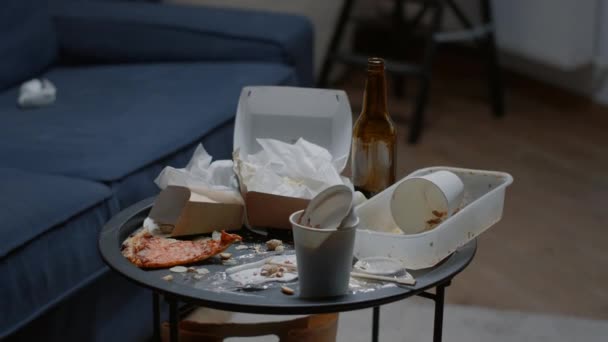 Sluiten van rommelige tafel, restjes eten, vuile vaat in lege woonkamer — Stockvideo