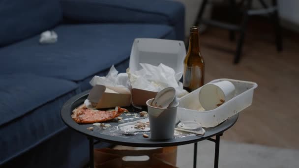 Gros plan sur les restes de nourriture sur la table dans le salon désordonné vide — Video