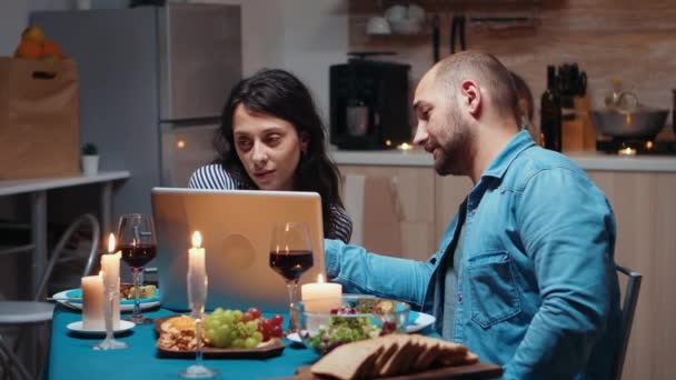 夕食時にノートパソコンを使うカップル — ストック動画