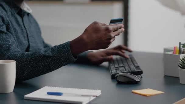 Primo piano di afro-americano uomo mani digitando informazioni sulla carta di credito sul keyborad del computer — Video Stock