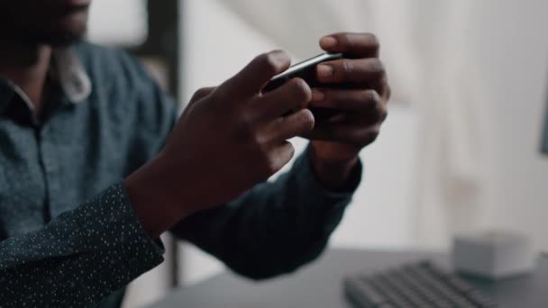 Primer plano de las manos del hombre negro jugando juegos de video móviles de Internet en línea — Vídeos de Stock