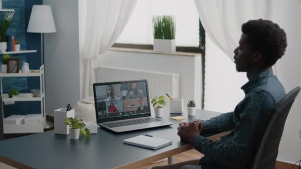 Czarny człowiek zdalny pracownik pracujący z domu biorąc online biuro połączenie — Wideo stockowe