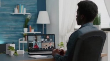 İnternet konferansında iş arkadaşlarıyla sohbet eden Afrikalı Amerikalı bir yönetici.