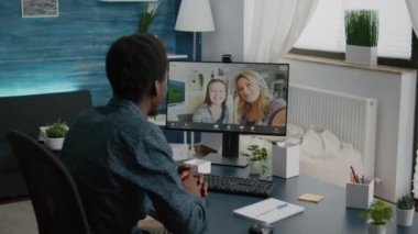 Çevrimiçi video iletişimi kullanarak ailesi ve arkadaşlarıyla konuşan Afrikalı Amerikalı bir adam.