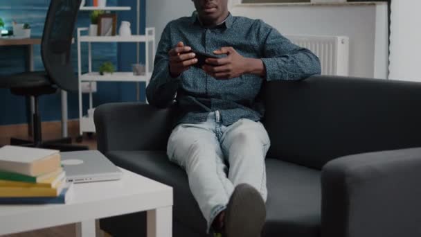 Hombre afroamericano jugando videojuegos en su teléfono — Vídeos de Stock