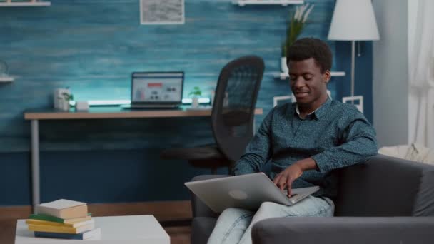 Afrikansk amerikansk man bläddrar med hjälp av bärbar dator, söker sociala medier — Stockvideo