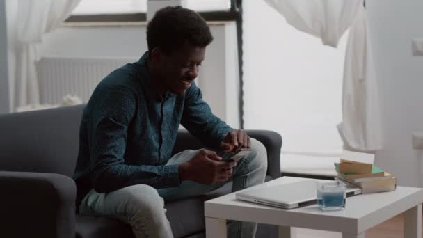 Positiv autentisk svart afrikansk amerikansk man ler när du använder en smartphone — Stockvideo