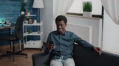 Çevrimiçi video konferans görüşmesinde konuşurken Afrikalı Amerikalı bir adam meslektaşlarını ya da ailesini selamlıyor