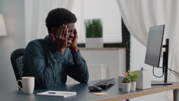 Afro-Amerikaanse man stressen met hoofdpijn, migraine, over zijn slapen wrijven — Stockvideo