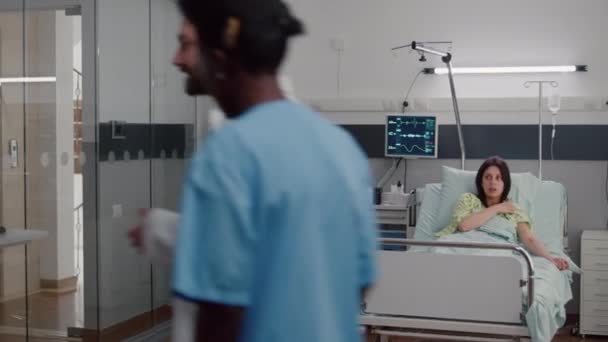 Спеціаліст лікар кладе оксиметр, перевіряючи пульс, розмовляючи з хворою жінкою — стокове відео