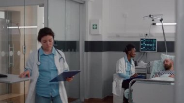 Afro-Amerikan doktor, hasta adam hastalıkları tedavisini tartışıyor.