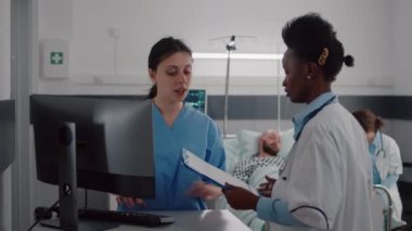 Uzman pratisyen doktorlar hasta adamı izlerken, tıbbi asistanlar hastalık belirtileri yazıyor.