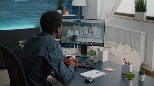 Bezorgd vader voor haar kleine meisje in het ziekenhuis afdeling, praten op video conference call — Stockvideo