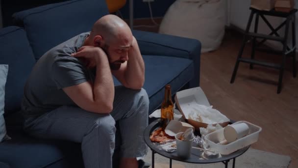 Pszichotikus egyedül depressziós férfi ül a kanapén és csalódott. — Stock videók