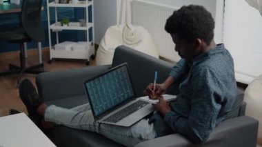 Afrikalı Amerikalı adam kripto para birimi borsalarını inceliyor borsada işlem yapıyor, borsa indeksini kontrol ediyor.