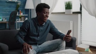 Afrikalı Amerikalı adam internetten telefonla video görüşmesi yapıyor.