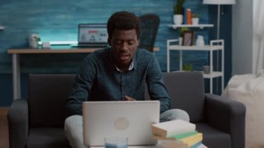 İnternetteki video konferansında iş arkadaşlarıyla konuşan Afrikalı Amerikalı bir adam.