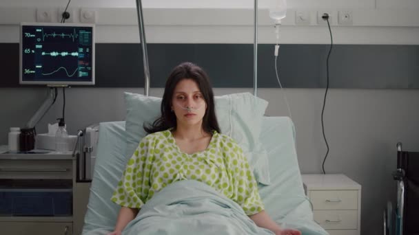 Portrét nemocné ženy nosící nosní kyslíkovou trubici odpočívající v posteli — Stock video