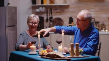 Yaşlı çift içki içerken eğleniyor.