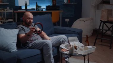 Bunalımlı adam müzik dinliyor, kulaklık takıyor, yalnız oturuyor.
