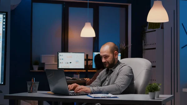 Uomo d'affari esausto che controlla le statistiche di marketing sul computer portatile — Foto Stock