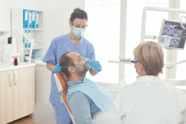 Fogászati ápoló Oxigén maszkot helyez a beteg vizsgálatára fogfájás — Stock Fotó