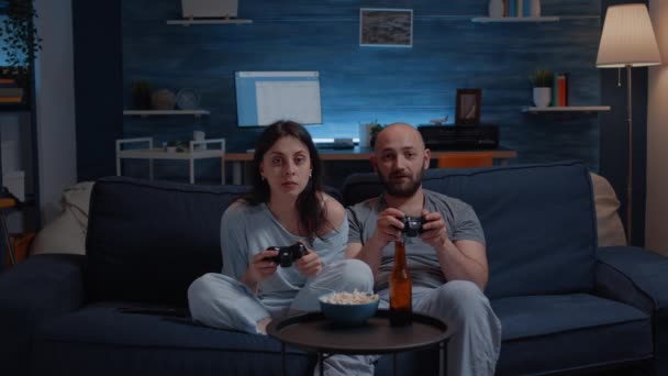 Зачарованная пара играла в видеоигру поздней ночью — стоковое видео
