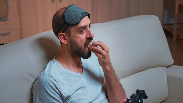 Pro gamer with sleep mask sitting in front of television playing videogames — Stock Photo, Image