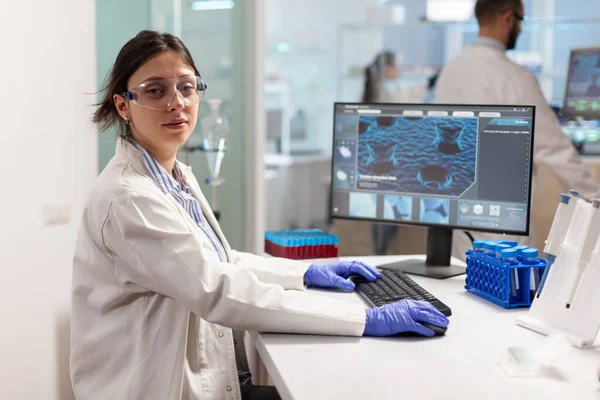 Portrait of scientist looking tired at camera sitting in modern laboratory — Stock Photo, Image