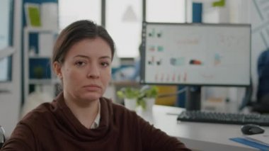 Kameraya üzgün bakan engelli bir iş kadını.